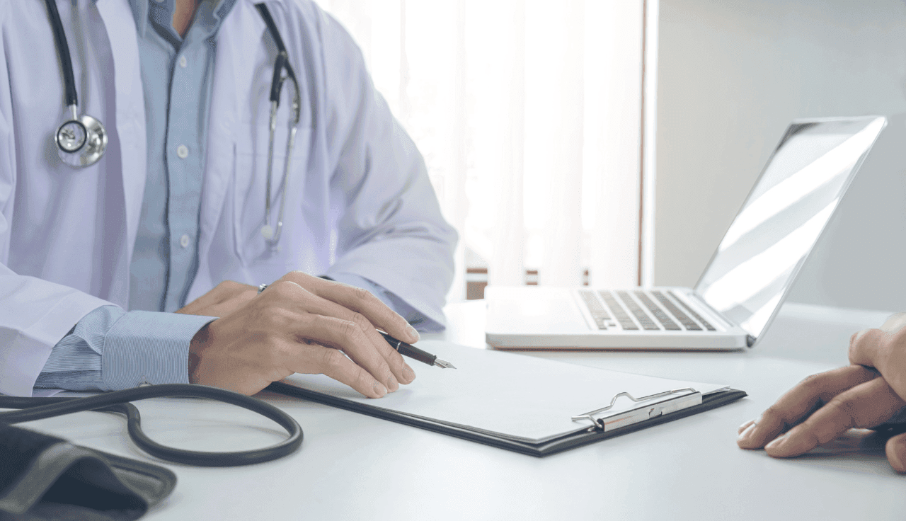 Arzt unterhält sich mit Patient und hat einen Stift in der Hand